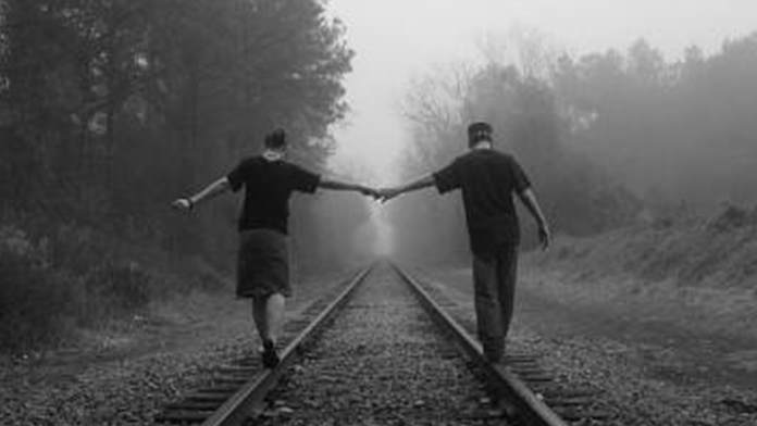 coppia che passeggia sulle rotaie