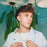 Foto di Valerio Mazzei su sfondo azzurro con palme