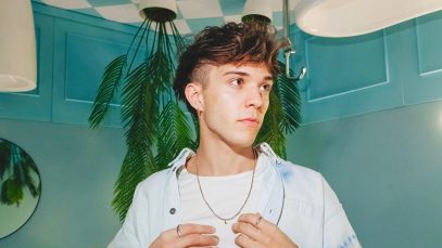 Foto di Valerio Mazzei su sfondo azzurro con palme