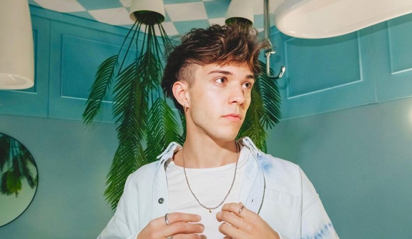 Foto di Valerio Mazzei su sfondo azzurro con palme