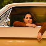 Emma affacciata al finestrino di una Mustang