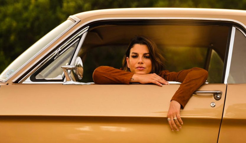 Emma affacciata al finestrino di una Mustang