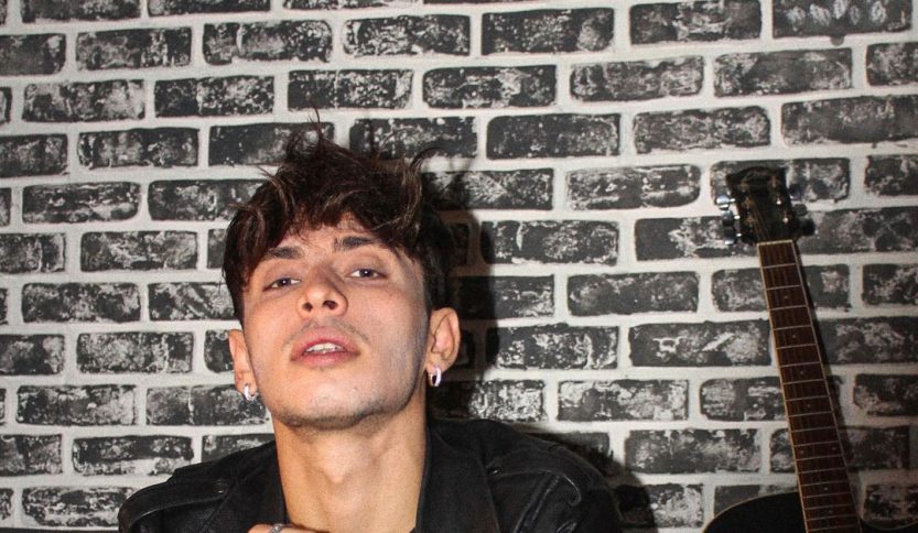 Deddy con chitarra e muro di mattoni