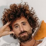 Gio Evan con sfondo bianco e cuscini