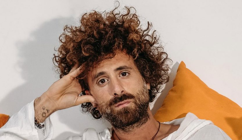 Gio Evan con sfondo bianco e cuscini