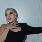 BigMama appoggiata a una parete bianca