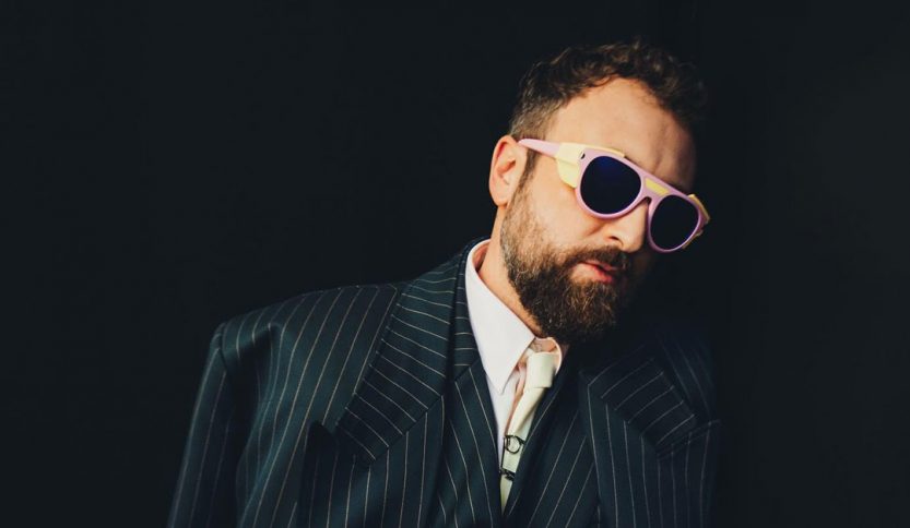 Dargen D'Amico davanti a un muro nero