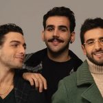 Il Volo davanti a una parete marroncina