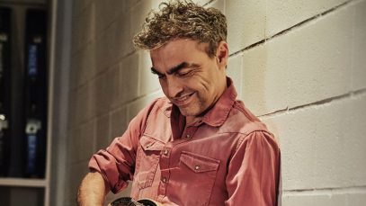 Marco Ligabue contro un muro con una chitarra