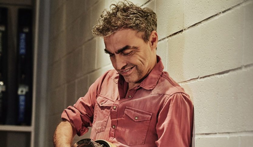 Marco Ligabue contro un muro con una chitarra