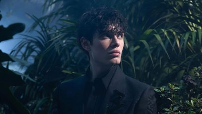 Biondo in un giardino con una rosa nera