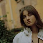 Elex in un giardino davanti a un palazzo