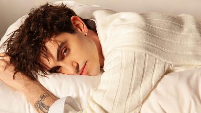 Michele Bravi su un letto bianco
