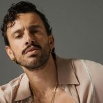 Aiello con sfondo grigio e camicia rosa