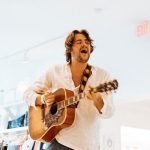 Grifoni mentre suona con muro bianco