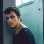 Ilan appoggiato a un vetro