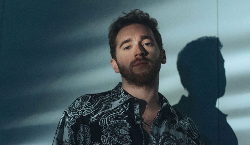 Nathan Trent con sfondo azzurro