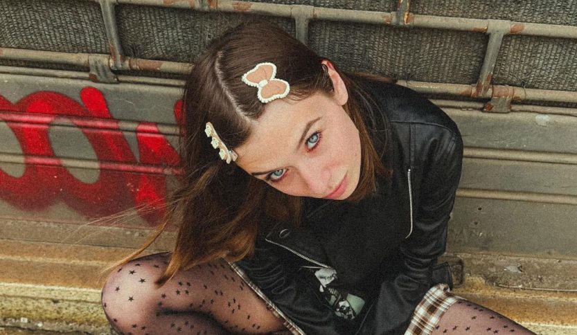 Greta Grida seduta su un marciapiede