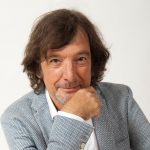 claudio cecchetto in posa su fondo grigio