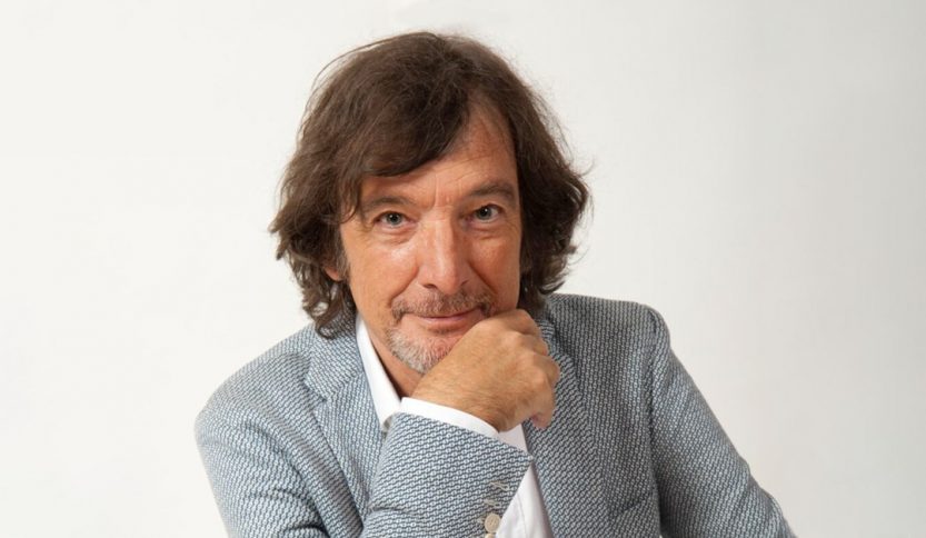 claudio cecchetto in posa su fondo grigio