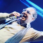 Pietro Ubaldi con sfondo blu e microfono