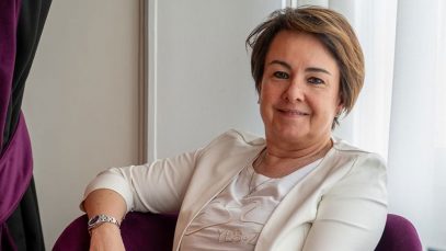 Foto di Lucia Fracassi con sfondo bianco e poltrona e tenda viola