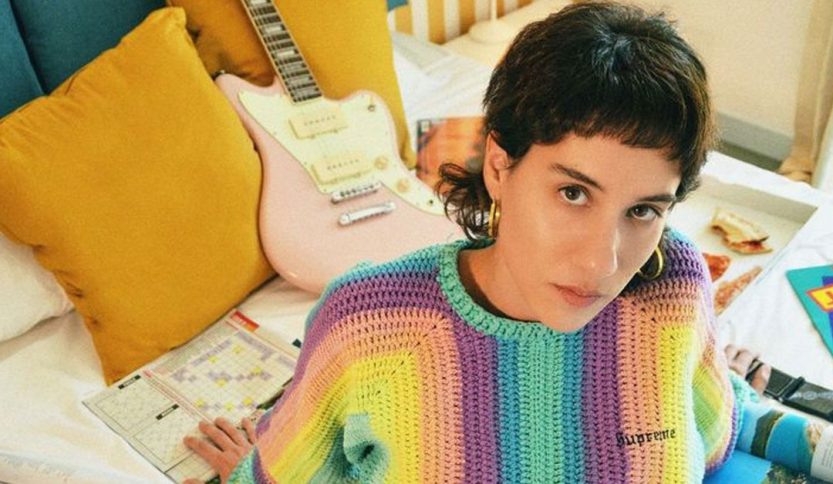 Anna and Vulkan su letto con oggetti dietro