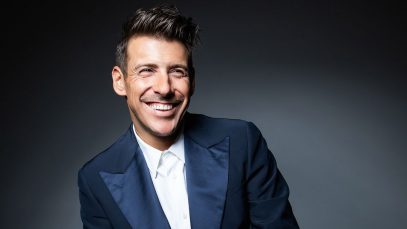 Francesco Gabbani sorride con sfrondo scuro