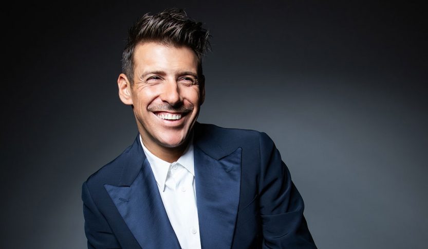Francesco Gabbani sorride con sfrondo scuro