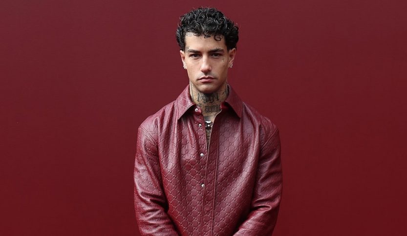 Tony Effe con sfondo rosso