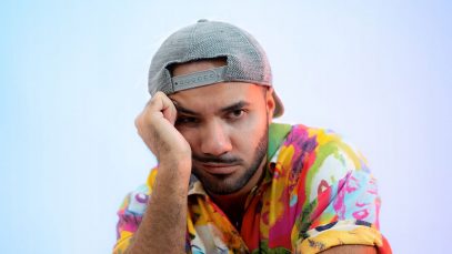 Alex Polidori con cappello e sfondo azzurro