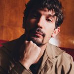 Pierdavide Carone con parete di legno alle spalle