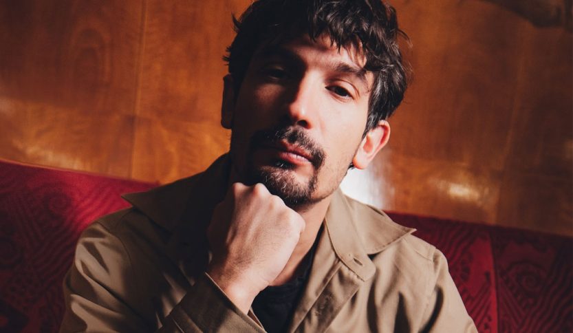 Pierdavide Carone con parete di legno alle spalle
