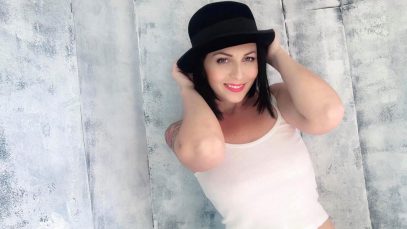 Loretta Di Pisa con un cappello e sfondo chiaro