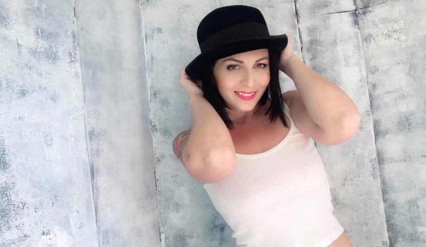 Loretta Di Pisa con un cappello e sfondo chiaro