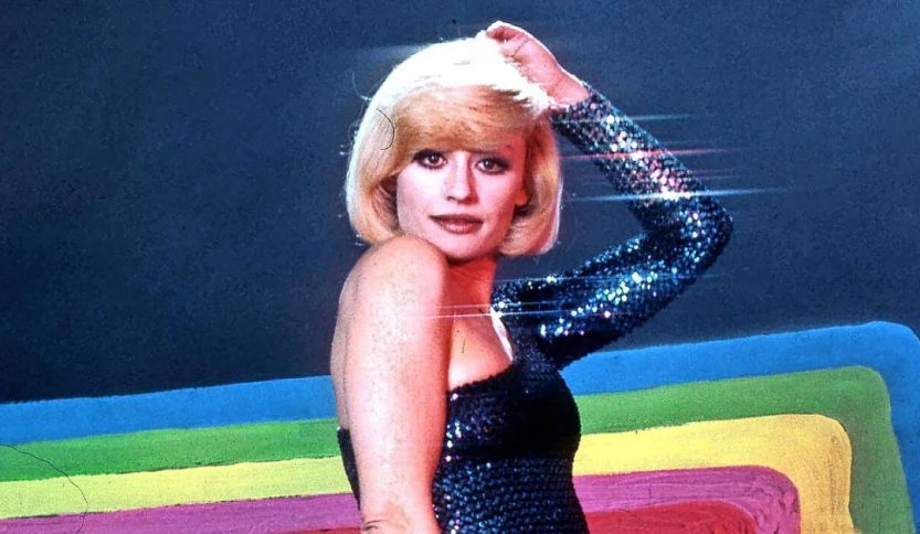 Raffaella Carrà con sfondo arcobaleno