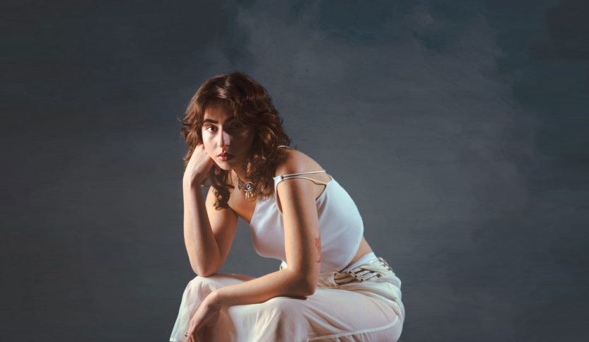 Lauryyn su una sedia con sfondo scuro