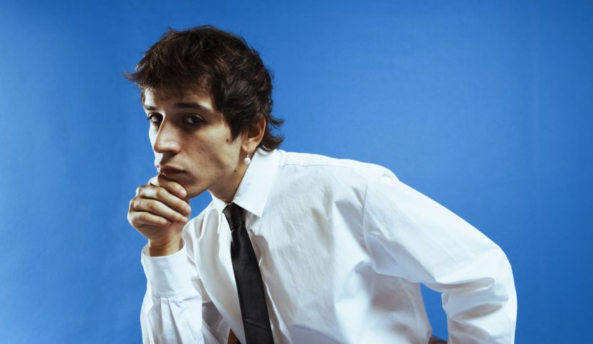 Alex Wyse con cravatta e sfondo azzurro