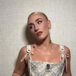 Mara Sattei con corsetto su sfondo beige