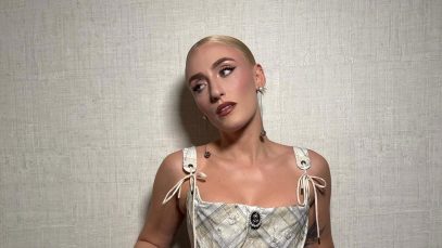 Mara Sattei con corsetto su sfondo beige