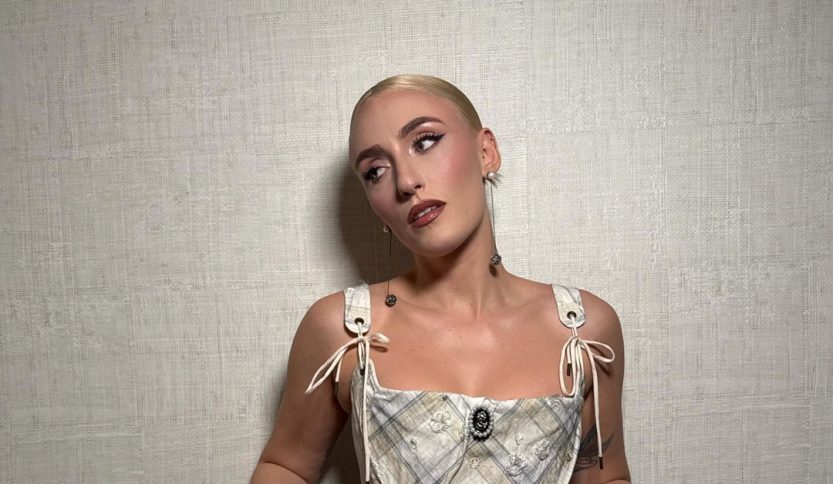 Mara Sattei con corsetto su sfondo beige