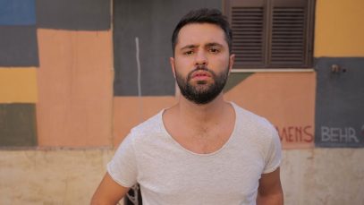 Santoianni con dietro un muro e un'anta marrone