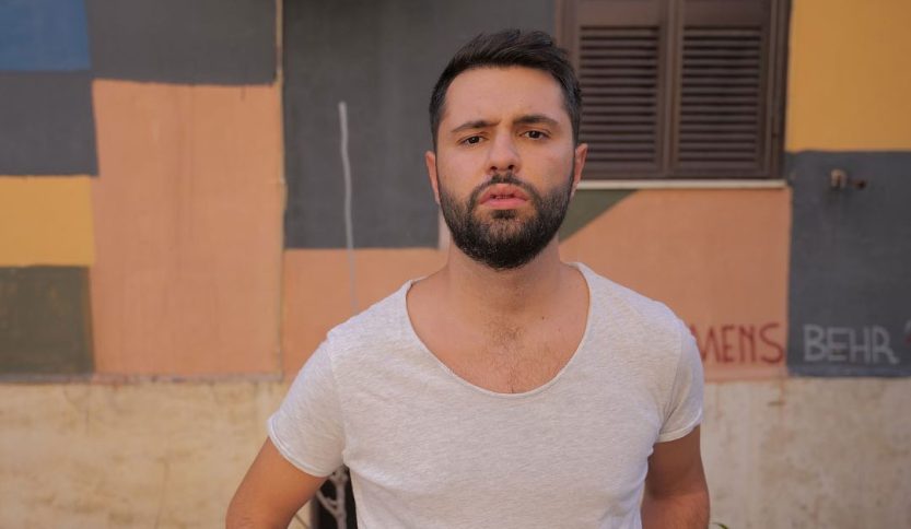 Santoianni con dietro un muro e un'anta marrone