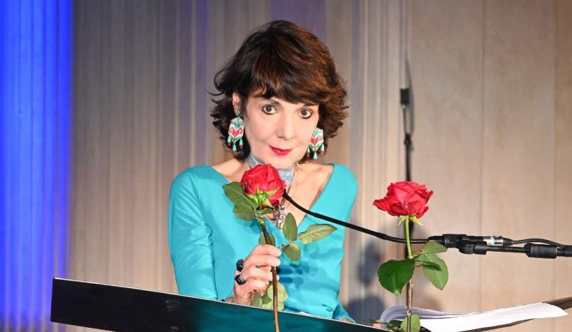 Elisabetta Sgarbi con una rosa davanti al leggio