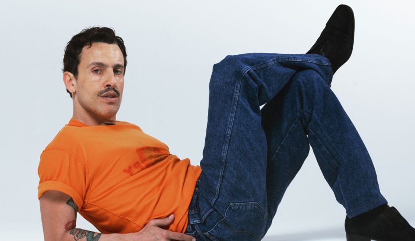 Aiello con maglia arancio e sfondo grigio